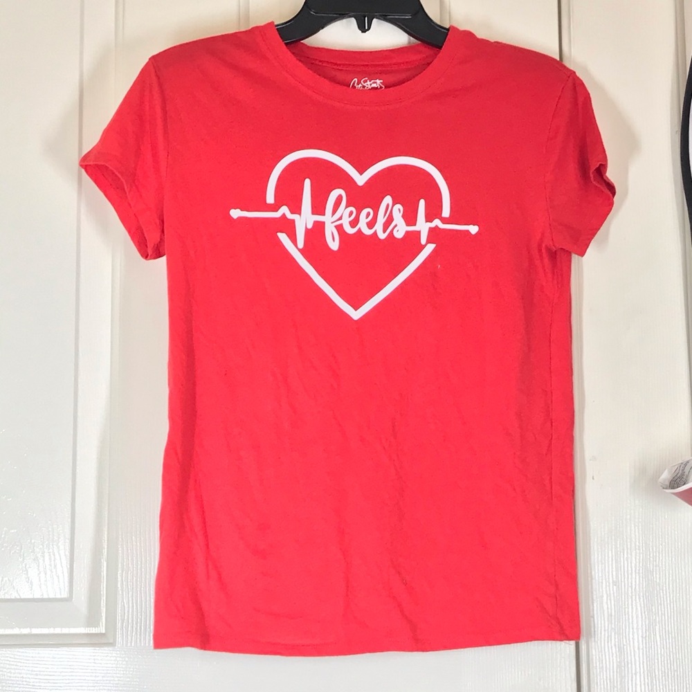 Red shirt with a heart in the middle of the shirt.